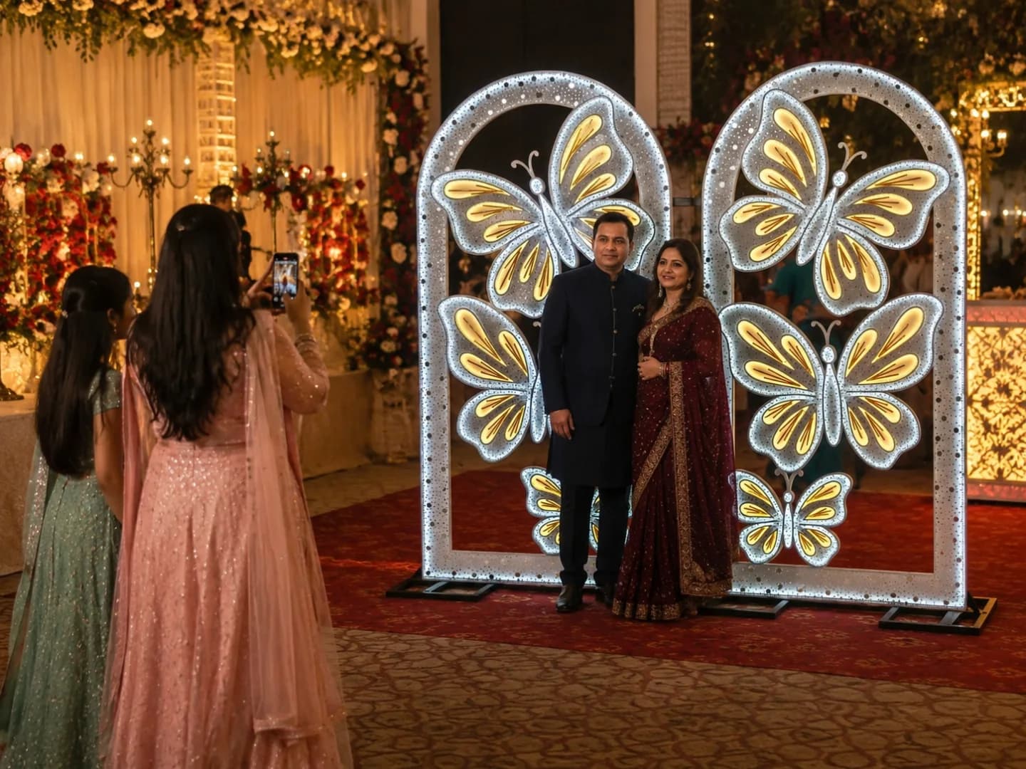 Guests posing for a photo at an LED butterfly selfie point at a wedding